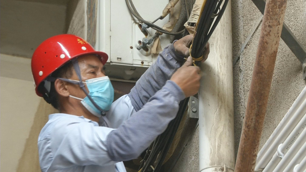 图为施工人员在老旧小区（向阳小区）对空中缆线进行捆绑.jpg