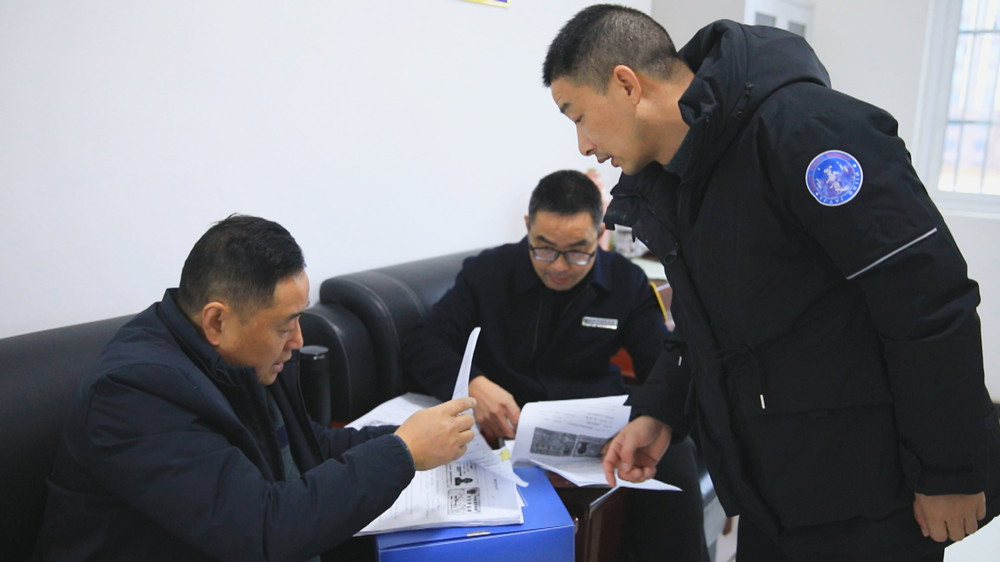 图为农民工维权工作组正在某项目工地查阅农民工工资发放台账.jpg