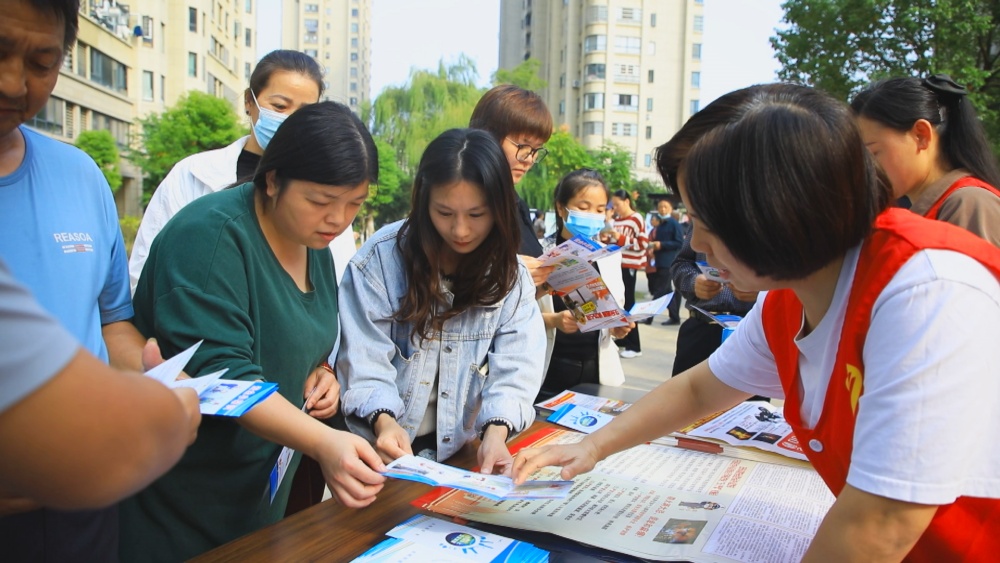 图为龙眠街道王墩社区工作人员正在给小区居民发放防灾减灾知识宣传单页2.jpg